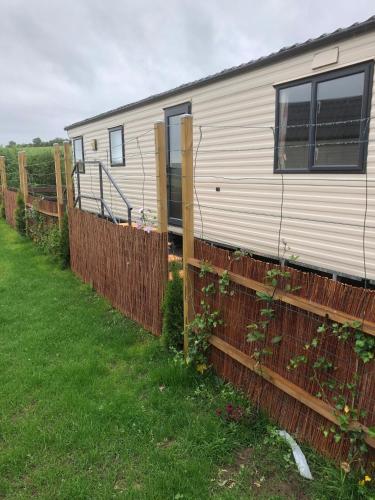 a white trailer behind a fence in a field at Ferienhaus Chilllout Chalets Daun-Kradenbach in Kradenbach