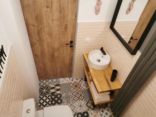 uma pequena casa de banho com um lavatório e um espelho em Central Park Studio Petrosani em Petroşani