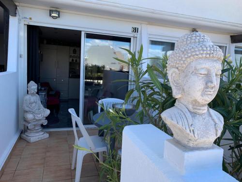 una estatua de una cabeza sentada sobre una mesa en Le Boudha Love, en Cap d'Agde