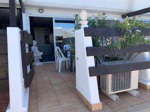 un porche con una valla con plantas. en Le Boudha Love, en Cap d'Agde