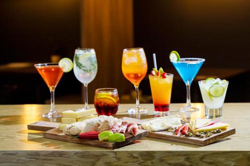 a table topped with different types of drinks and appetizers at Novotel Itu Terras de São José Golf & Resort in Itu