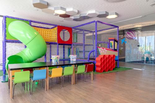 a play room with a table and a slide at Novotel Itu Terras de São José Golf & Resort in Itu