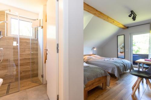 a bedroom with a bed and a glass shower at Hotel Landhaus Lungau in Sankt Michael im Lungau
