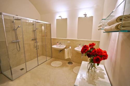 a bathroom with a shower and a vase of red flowers at Malandrì B&B in Altamura