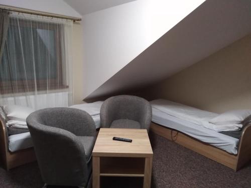 a room with two chairs and a bed and a table at Ośrodek Wczasowy "Wczasy pod gruszą" in Biecz