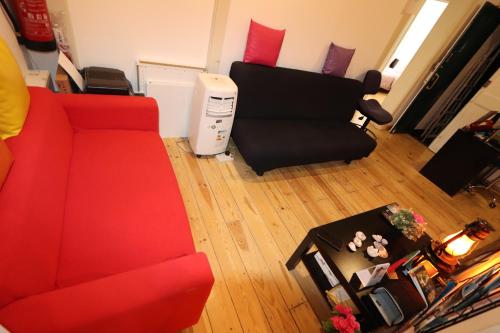 a living room with a red couch and a chair at City Center Guest House in Lisbon