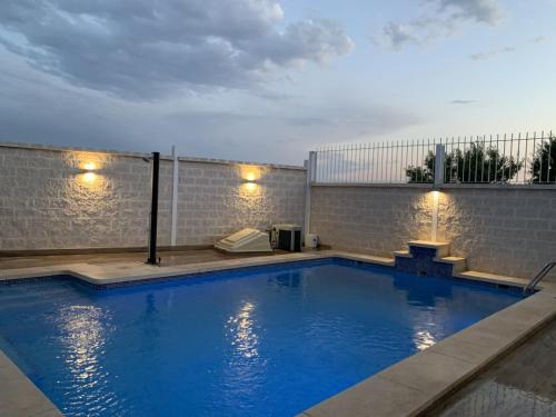 a large blue swimming pool with lights on a building at Casa rural Alcala Cabaña Del herrero in Alcalá del Júcar