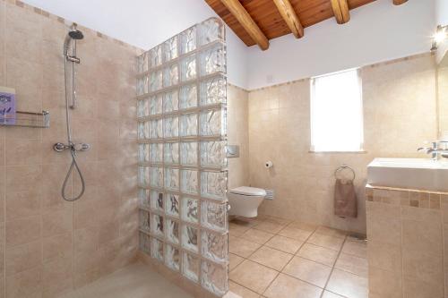 y baño con ducha, aseo y lavamanos. en Villa Diane Luxury Cottage Ocean views pool, en Benagil