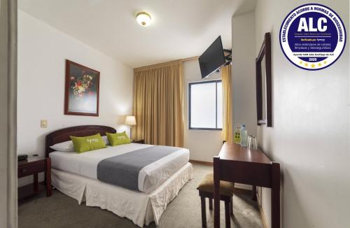Pokój hotelowy z łóżkiem i biurkiem w obiekcie Ayenda 1408 Jaba Santiago de Cali w mieście Cali