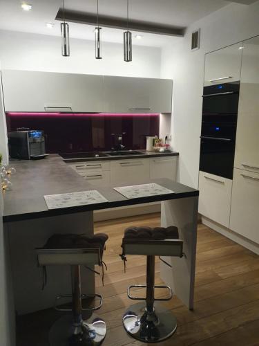 a kitchen with a counter and two bar stools at Apartament Platinum in Malbork