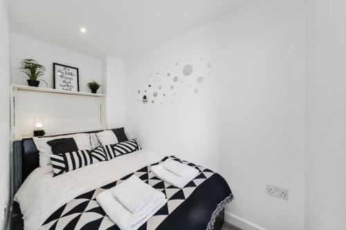 a bedroom with a bed with black and white pillows at Cosy Apartment in the Heart of the City in London