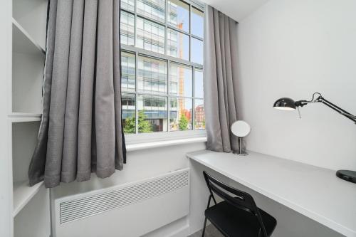 Habitación con escritorio y ventana. en Cosy Apartment in the Heart of the City, en Londres