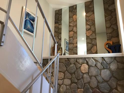 a staircase in a house with a stone wall at Steps to the Sand and Main Street 4BR in Huntington Beach