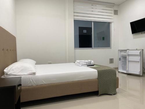 a bedroom with a large bed and a window at CasaBlanca ApartaEstudios in Girardot