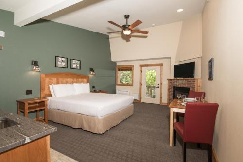 a bedroom with a bed and a desk and a television at The Maxwell Inn in Estes Park