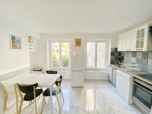 a white kitchen with a white table and chairs at 022 CHIC & COSY GRAND APPART DUPLEX 92m2 WIFI SMART TV NETFLIX in Saint-Étienne