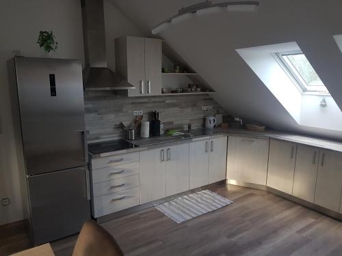 a kitchen with white cabinets and a large window at Ubytování U Špačků Pálava in Novosedly