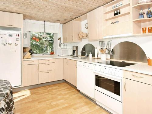 een keuken met witte apparatuur en een houten plafond bij 6 person holiday home in Vinderup in Vinderup