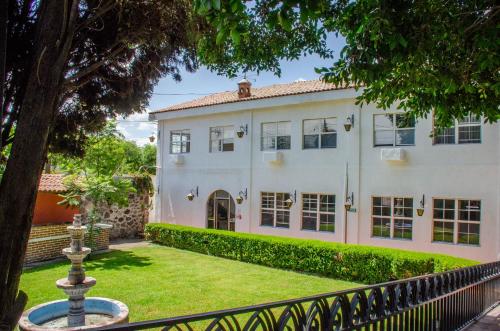 an exterior view of a white house with a fence at Hotel O Puente in San Juan del Río