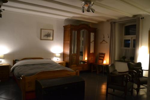 een slaapkamer met een bed en stoelen in een kamer bij het Bakhuis in Hoensbroek
