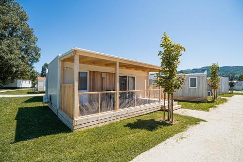 a small house with a porch on the grass at Mediteran Homes with Terme Čatež Tickets in Čatež ob Savi