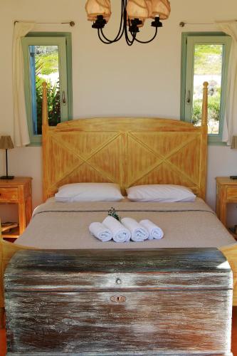 a bedroom with a bed with two towels on it at Aegean Blue Houses in Mandrakia