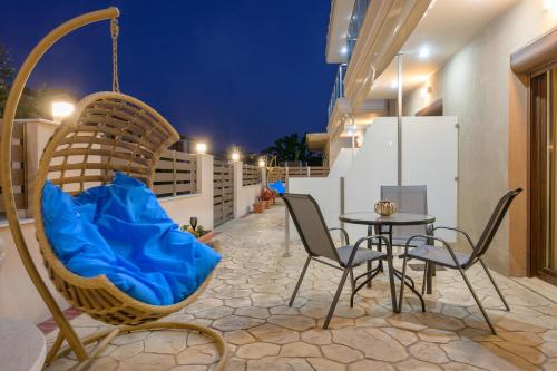 a patio with a swing and a table and chairs at M&B boutique apartments in Nea Roda