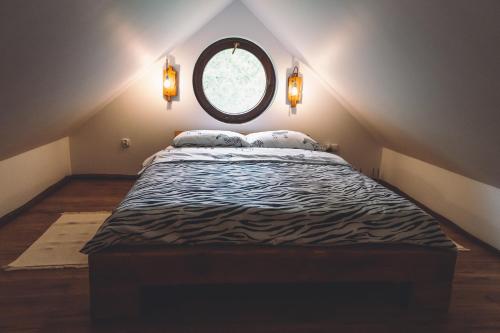 a bedroom with a large bed with a round mirror at LEŚNA STRZECHA APARTAMENTY in Rotembark