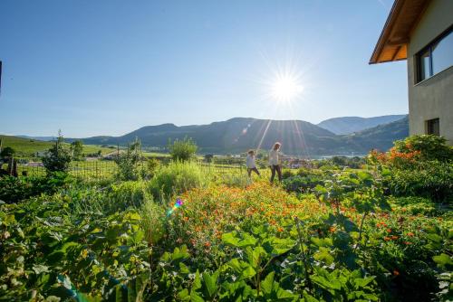 two people walking in a garden with flowers at Rösslhof in Caldaro