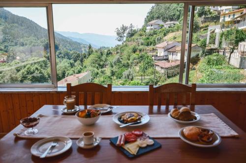 a table with plates of food on it with a view at Nations Gerês - Bed & Breakfast in Geres