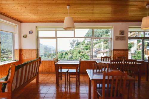 a restaurant with tables and chairs and a large window at Nations Gerês - Bed & Breakfast in Geres