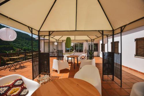 un patio cubierto con mesas, sillas y una mesa en Nations Gerês - Bed & Breakfast, en Gerês