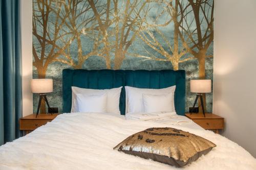 a bedroom with a bed with a blue head board at Willa Fen in Karpacz