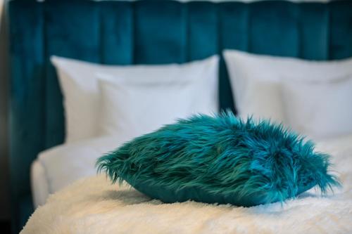 a blue stuffed animal sitting on top of a bed at Willa Fen in Karpacz