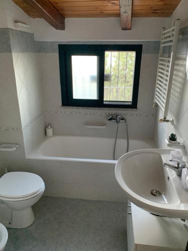 a bathroom with a tub and a toilet and a sink at Villa Mimma in Taormina