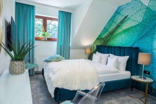 a bedroom with a bed with a blue and green wall at Willa Fen in Karpacz