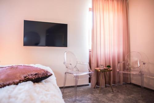 a bedroom with two chairs and a television on the wall at Willa Fen in Karpacz