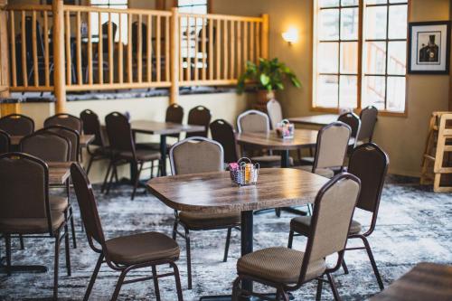 Glacier House Hotel & Resort في ريفيلستوك: غرفة مع طاولات وكراسي في مبنى