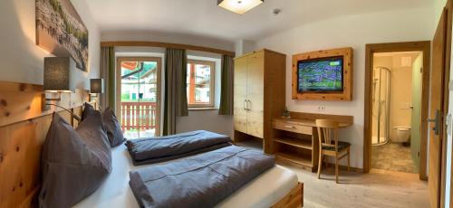 a bedroom with a bed and a desk and a television at LA MONTANA - Ski & Hiking LODGE in Schladming