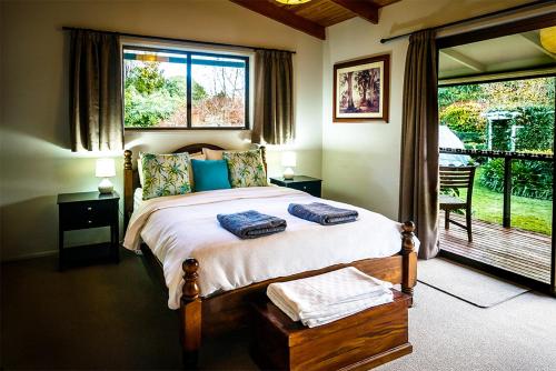 a bedroom with a bed and a large window at Bundara - Idyllic Getaway in the Mountains in Mount Tamborine