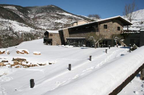 a snow covered yard in front of a building at Hotel Rural-Spa Resguard Dels Vents in Ribes de Freser