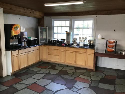a large kitchen with wooden cabinets and windows at Stonybrook Motel & Lodge in Franconia