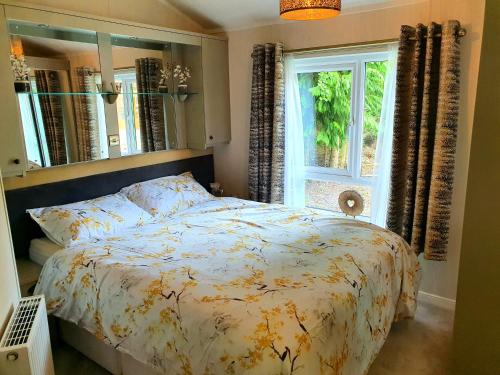 Un pat sau paturi într-o cameră la Grand Eagles Luxury Lodge, Auchterarder