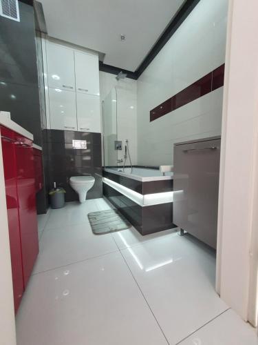 ein Badezimmer mit einer Badewanne, einem Waschbecken und einem WC in der Unterkunft Apartament Silver in Malbork