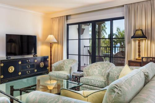 a living room with a couch and chairs and a tv at Santa Barbara Inn in Santa Barbara