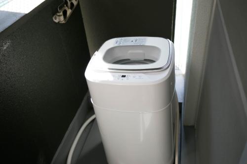 a white toilet in a corner of a room at Wings Hakata in Fukuoka
