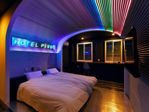 a bedroom with a bed with a neon sign at Hotel Pivot Shin-Imamiya Ekimae in Osaka