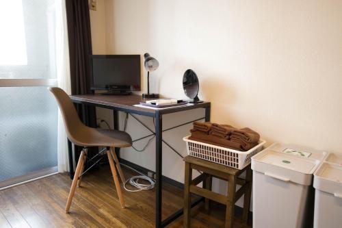 a desk with a computer and a chair in a room at Wings Hakata in Fukuoka