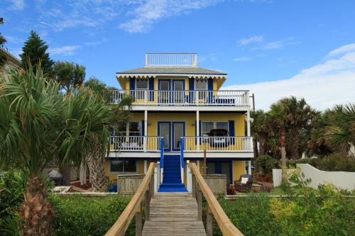 una casa amarilla con una escalera azul que conduce a ella en Bayfront Marin House, en St. Augustine