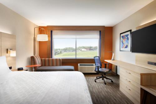 a hotel room with a bed and a desk and a window at Holiday Inn Express Calhoun South, an IHG Hotel in Calhoun